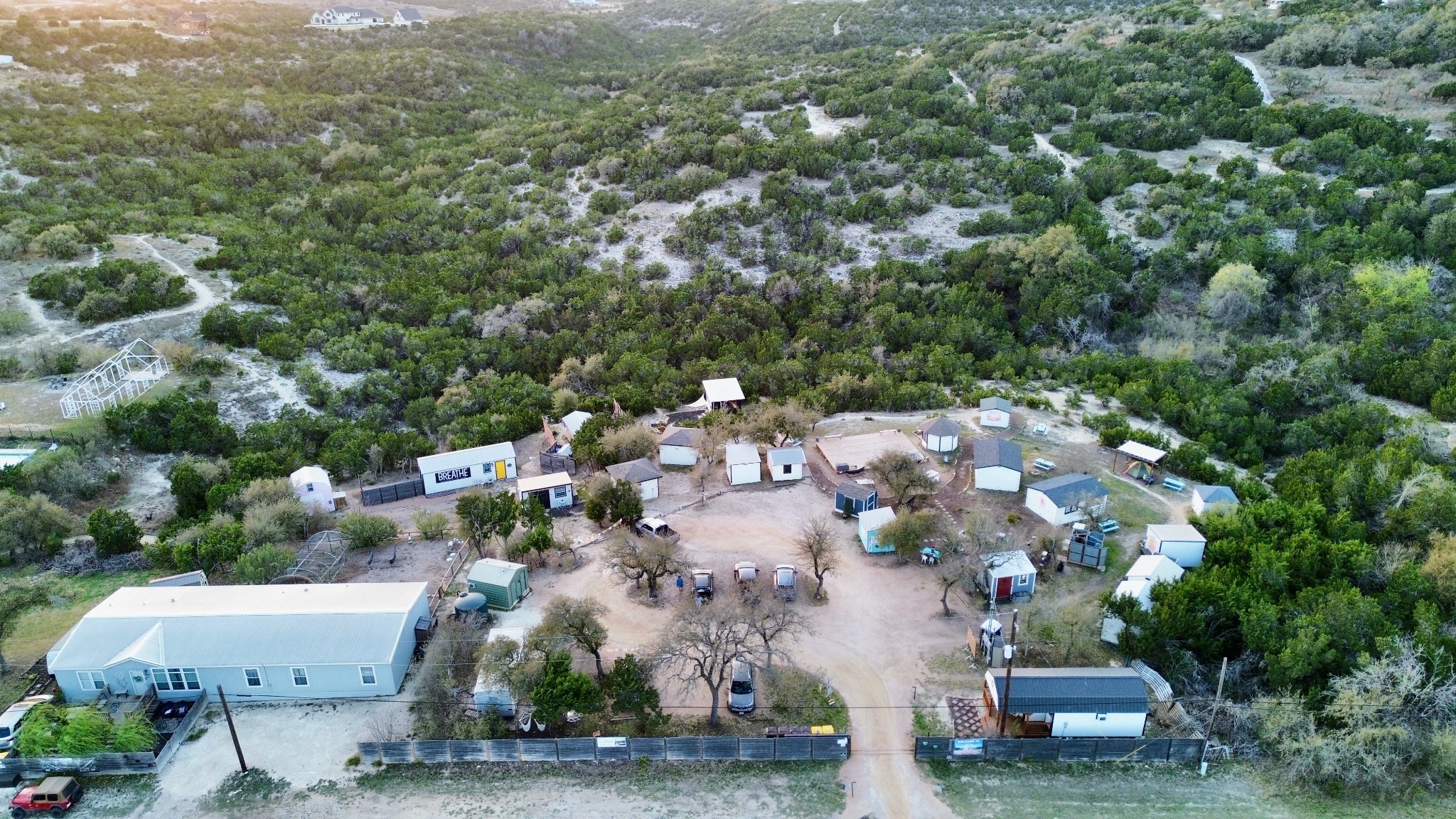 Aerial view of 13 Acres cabins surrounded by wooded Hill Country trails