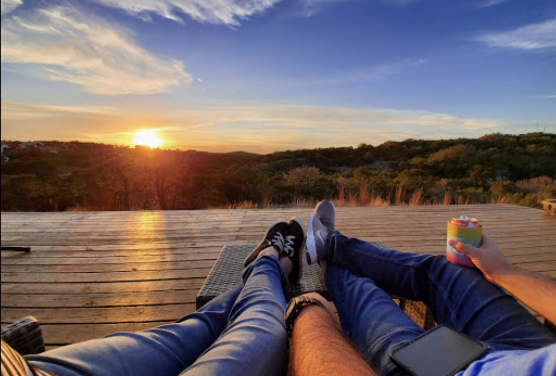 Guests relaxing on the 13 Acres deck as the sun sets over the Hill Country